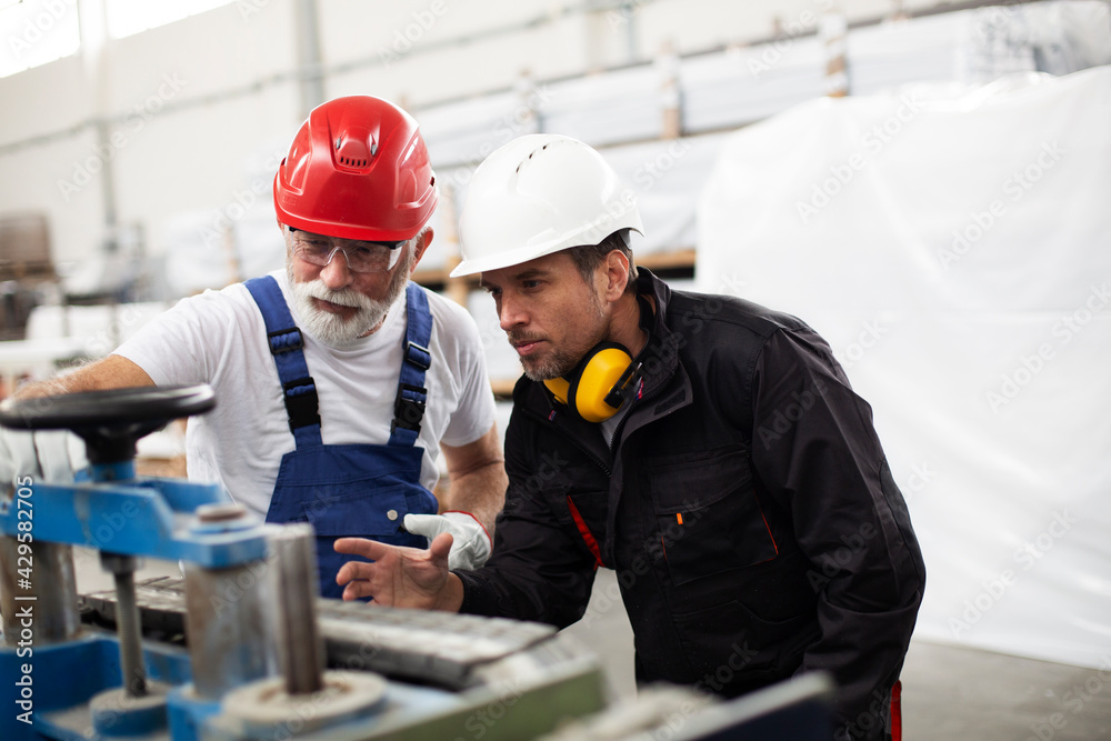 Portrait of workers in factory. Colleagues with helmet working in factory. Portrait of workers in factory. Colleagues with helmet working in factory.