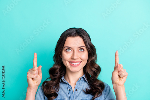 Photo of young girl happy positive smile look point fingers empty space advert choice select isolated over turquoise color background