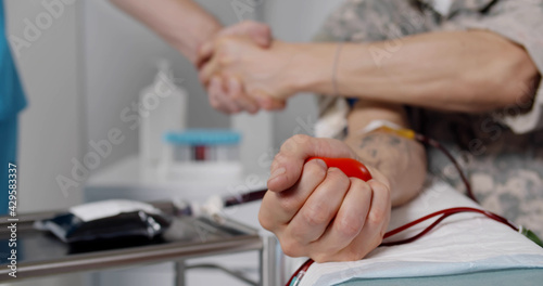 Εκτύπωση καμβά Close up of military officer donating blood and shaking hands with nurse