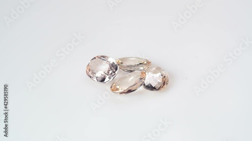 natural morganite gemstone on the white background on the turning table photo