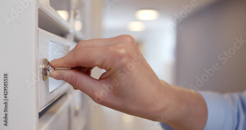 Canvas Print Close up of young woman opening postbox and taking mail