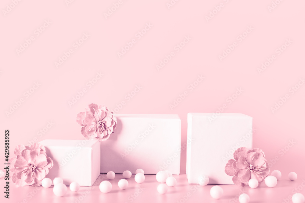 Pink toned empty stands decorated  flowers on color background.