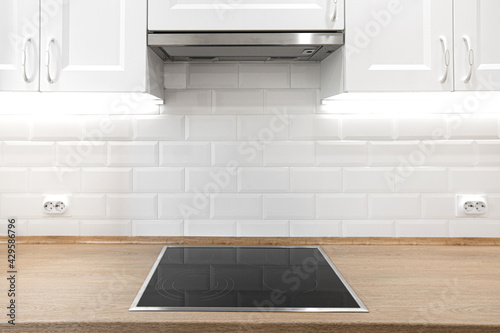 White kitchen with wooden countertop with induction cooktop photo