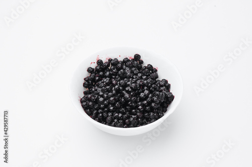 Bilberry on white plate isolated on white background. Top view. Free space for your text.