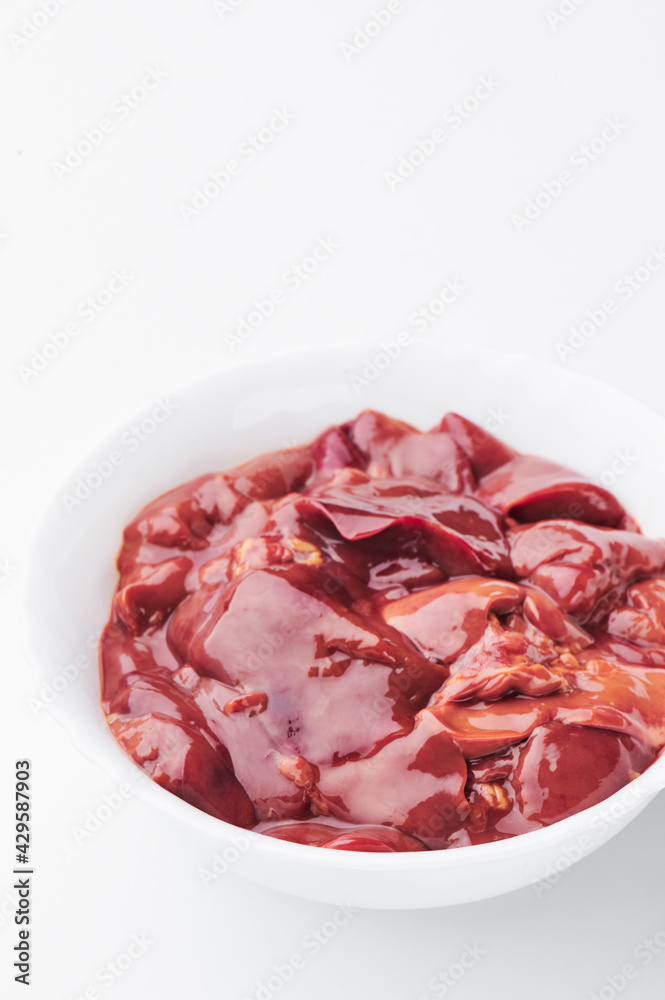 raw chicken liver in a white plate on a white background. Mockup 