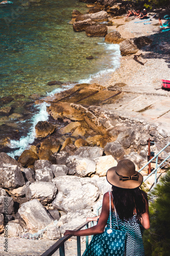 Woman in a hat looking at thesea on the beach photo