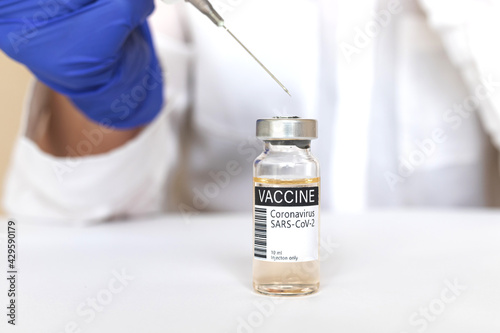 Doctor in blue gloves with syringe uses COVID-19 vaccine, vaccination concept background in hospital, medicine and healthcare photo