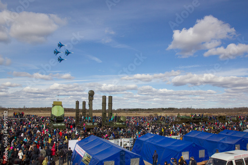 an air show in the sky during a city holiday. the country's air force demonstrates aerobatics flying over the audience. combat helicopters and planes on a show-off performance