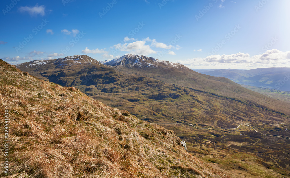 The mountain summits of Ben Lawers, Meall Corranaich and Beinn Ghlas from below Meall nan Tarmachan with Loch Tay off to the right in the winter Scottish Highlands, UK Landscapes.