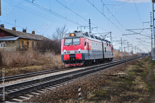 A moving train through the countryside. Railroad with train. Spring, day. View from the front.