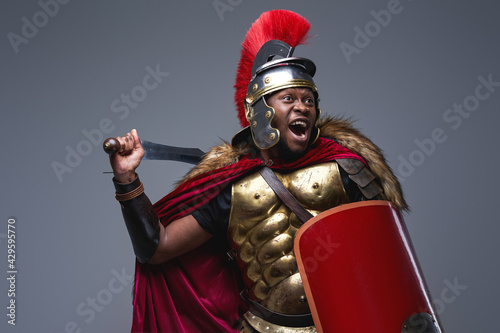 Screaming roman warrior assaults against gray background