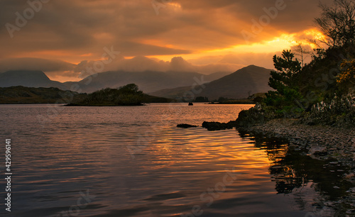 Beautiful morning orange sunrise scenery at Derryclare Lough with mountains in the background in Athry, County Galway, Ireland  photo