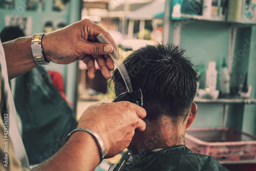 closeup hairstylist in barber shop.Hairdresser makes hairstyle a man