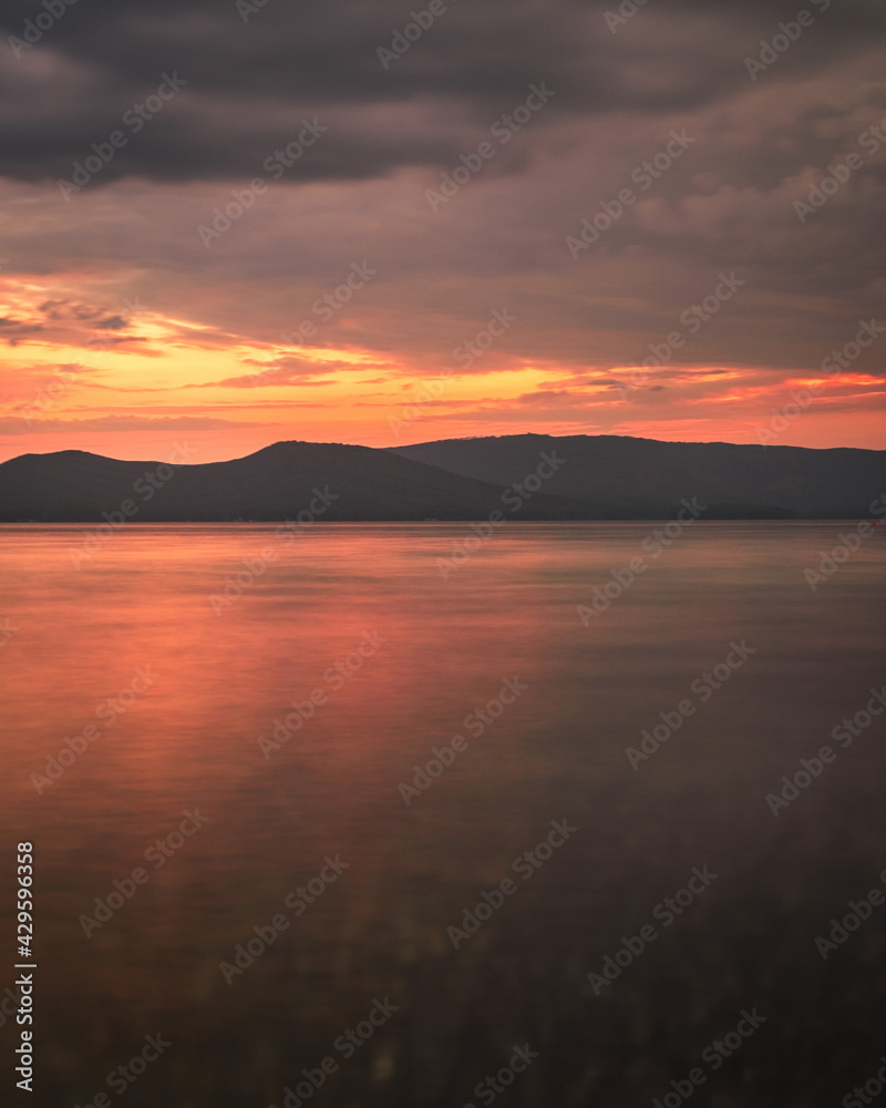 Photography of the sunset on the sea. Orange reflection on the water, mountains in the background. Dramatic view, breathtaking seascape. Golden sun rays. Photography of the sunset on the sea. Orange reflection on the water, mountains in the background. Dramatic view, breathtaking seascape. Golden sun rays.