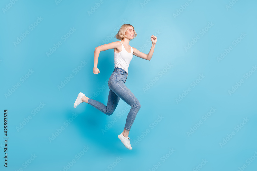 Full length profile photo of carefree charming lady look empty space rush isolated on blue color background