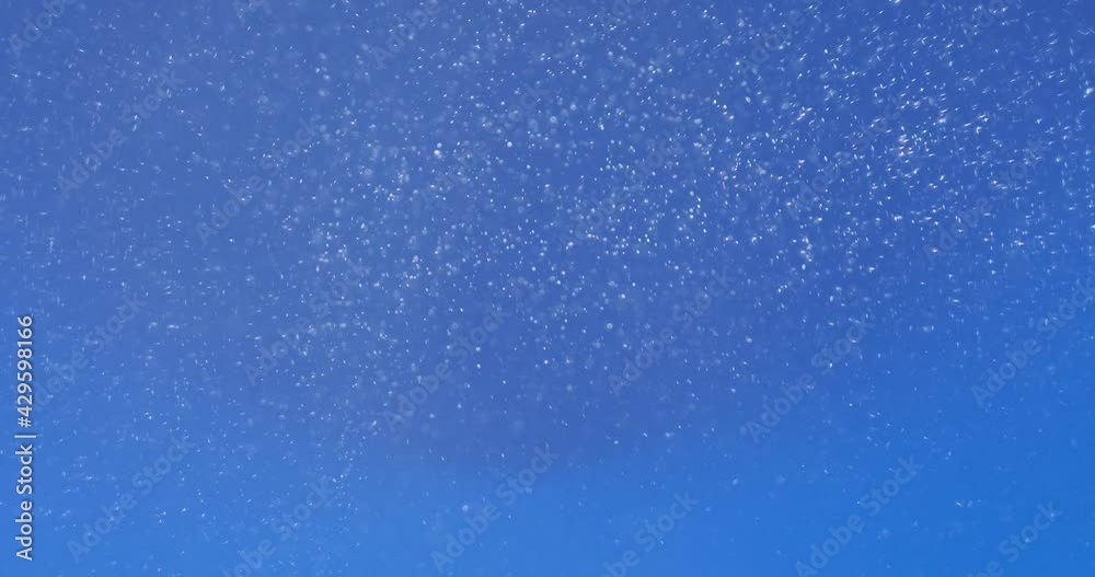 Exploding abstract white dust particles over blue background Exploding abstract white dust particles over blue background