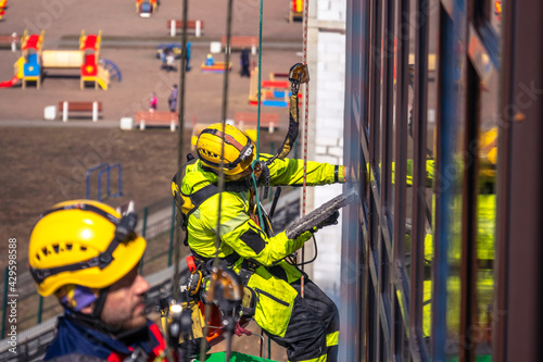 Картината върху платно Climbers wash the glazing of the facade
