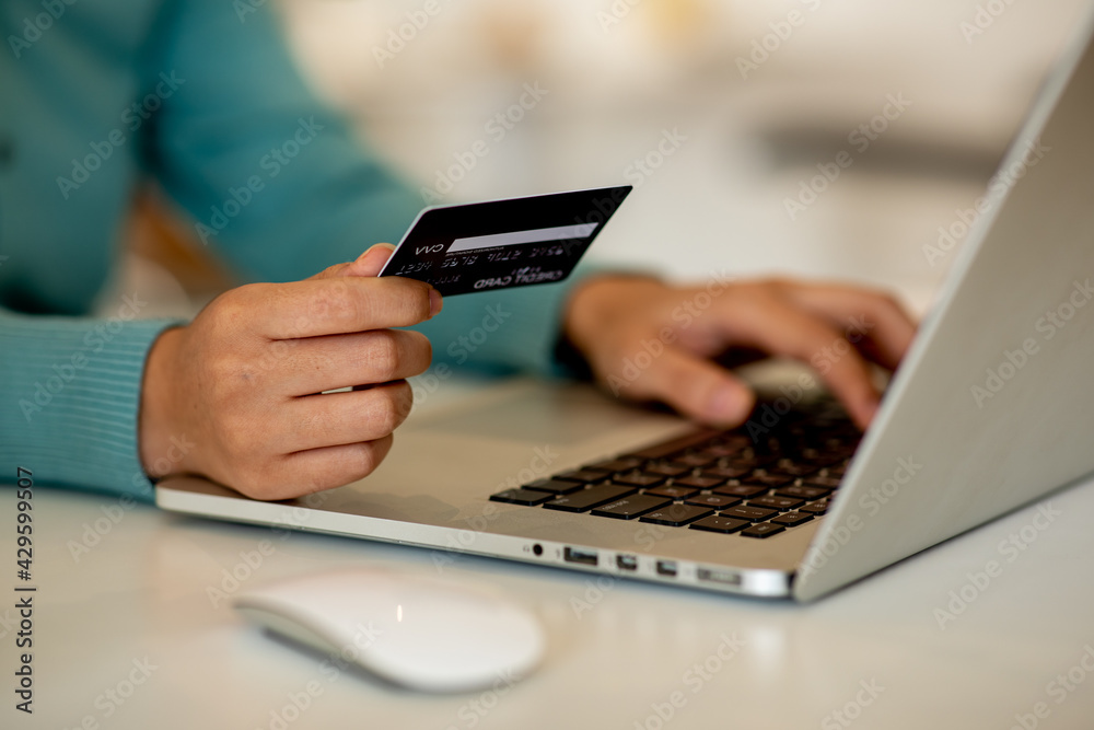 Close up woman hand using credit card and smartphone laptop for buying online shopping Close up woman hand using credit card and smartphone laptop for buying online shopping