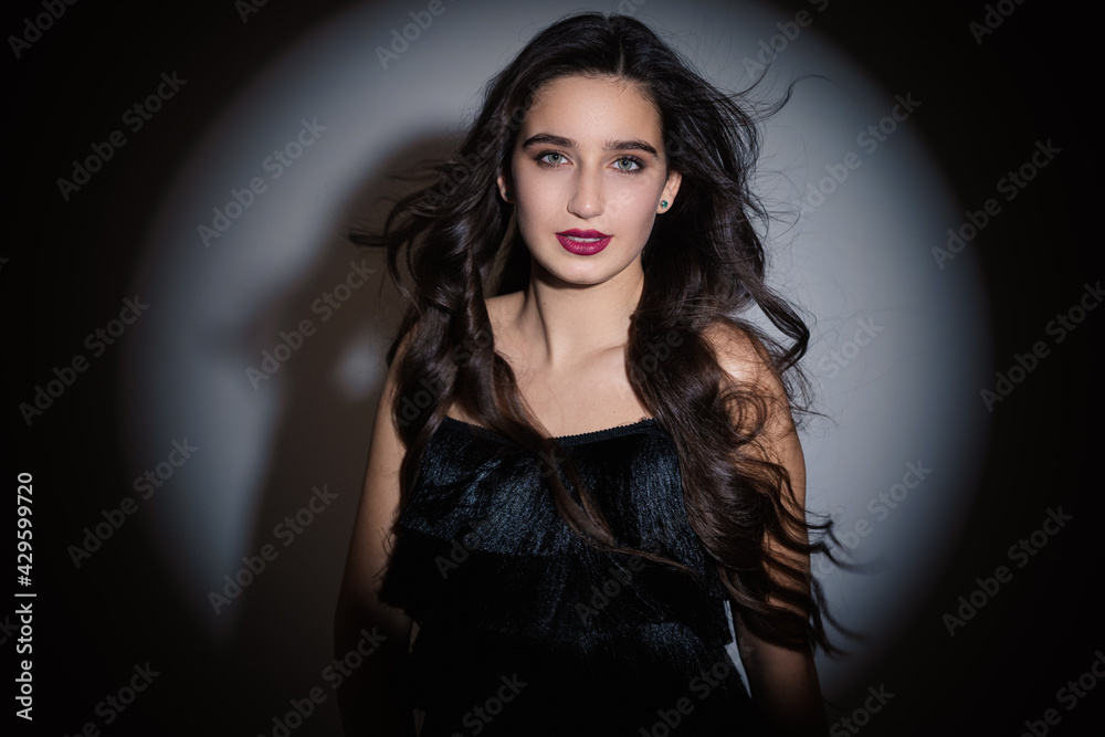Photo of a young girl with professional makeup. The hair is scattered back. Looking into the camera with green eyes. Photo of a young girl with professional makeup. The hair is scattered back. Looking into the camera with green eyes.
