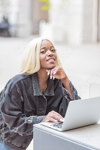 beautiful young afro-entrepreneur in the city of lyon france using her laptop