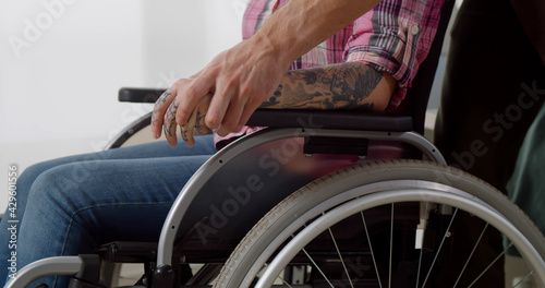 Cropped shot of disabled woman in wheelchair holding boyfriend hand