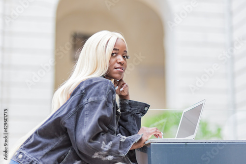 beautiful young afro-entrepreneur in the city of lyon france using her laptop