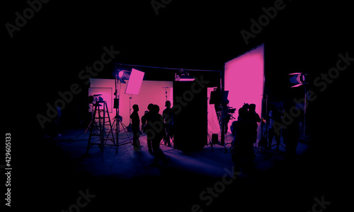 Silhouette images of film production. behind the scenes or b-roll of making video commercial movie. Film crew lightman and cameraman working together with film director in studio. Film industry. photo