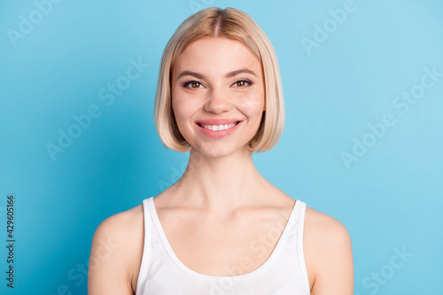 Photo of happy positive charming young lady smile face good mood wear singlet isolated on blue color background