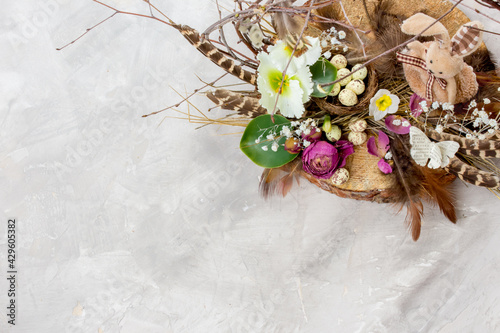 Easter composition with easter bunny, eggs and flowers on grey background