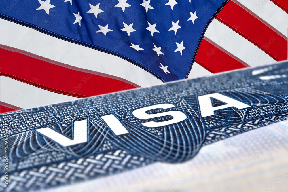 Obraz premium US American visa on passport over an American flag background. 