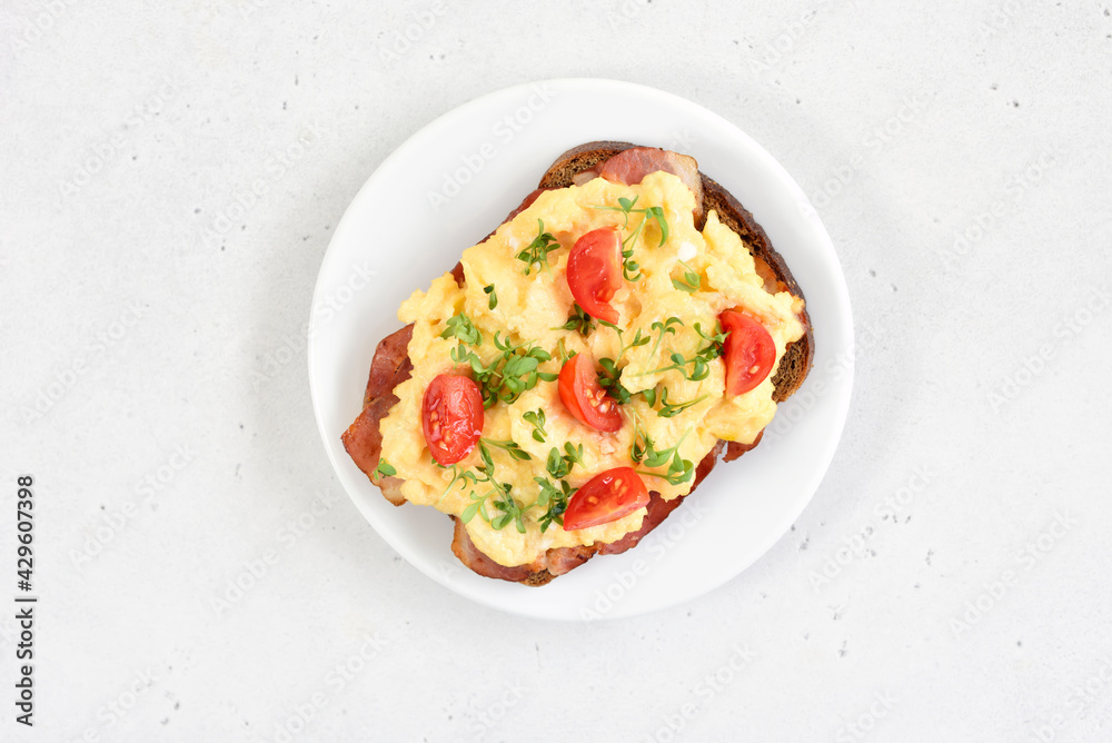 Scrambled eggs with microgreen and tomatoes on bread Scrambled eggs with microgreen and tomatoes on bread