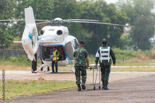 The nurse was moving the patient from the stretcher to the helicopter. To forward the patient by air photo
