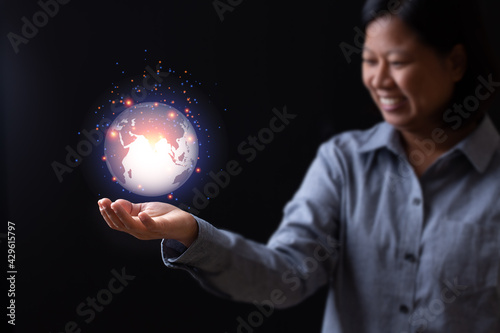 Business woman hand holding earth planet technology creative connection internet networking commucation, female smile looking light orange network graphic inspiration design abstract background.