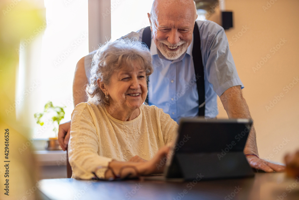 Happy senior couple using digital tablet at home
