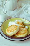 Cottage cheese pancakes, syrniki, curd fritters with sour cream. Breakfast. Selective focus. Tinted photo.