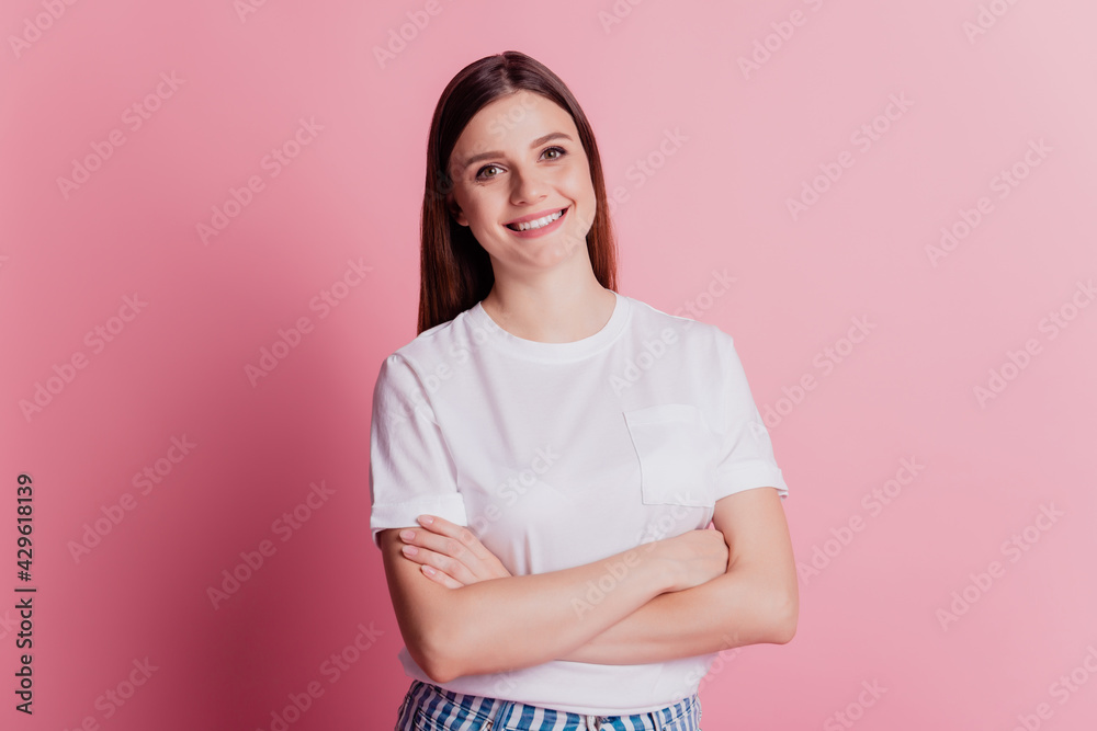 Obraz premium Young smiling cheerful girl look at camera folded arms shiny white smile on pink wall