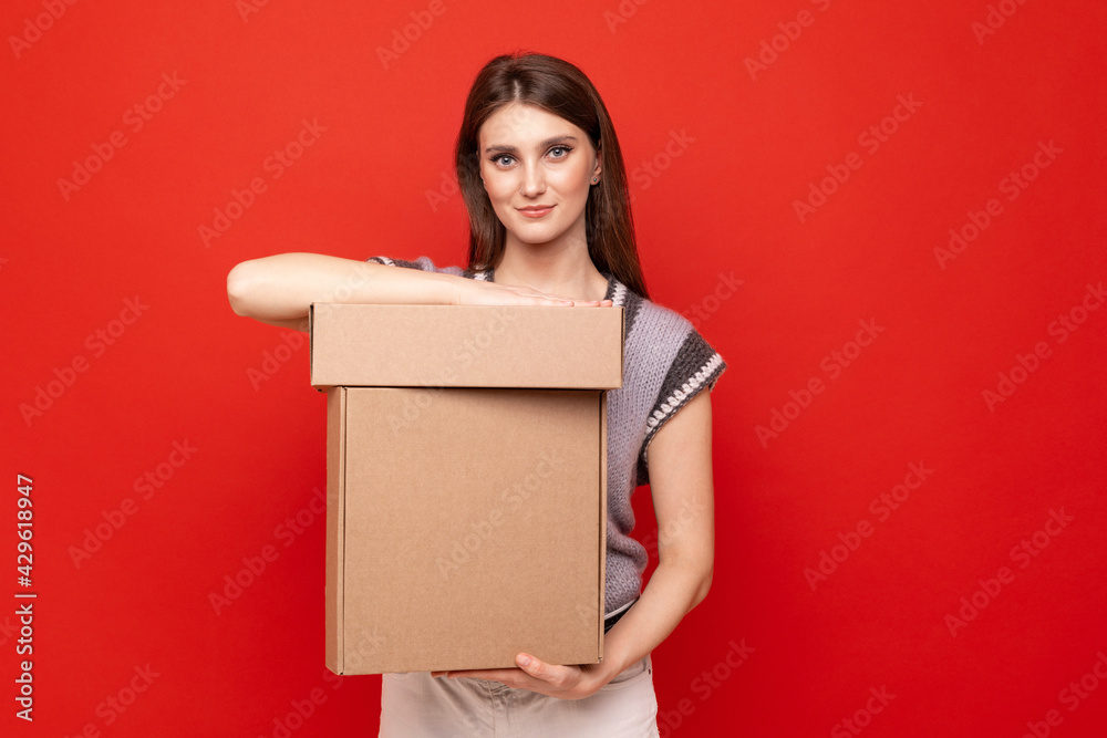 Young woman holding cardboard boxes on red background Young woman holding cardboard boxes on red background