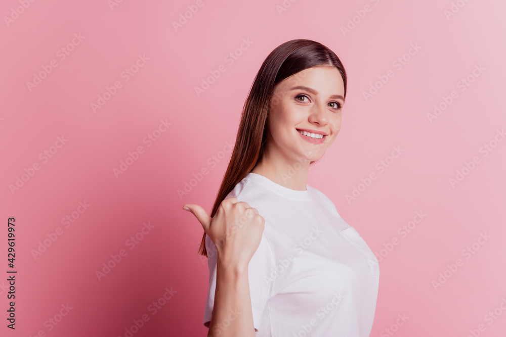 Positive adviser young woman showing way with thumb fingers direct back empty space Positive adviser young woman showing way with thumb fingers direct back empty space