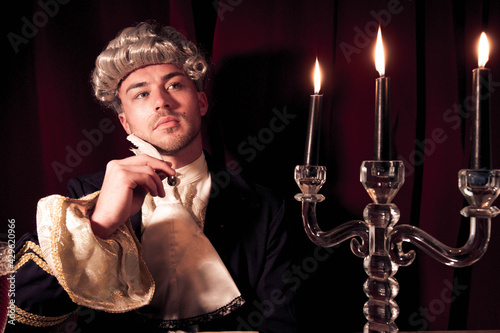 Canvas Print Portrait of young man dressed in regency costume and wig sitting at writing desk