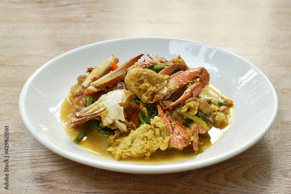 stir fried swimmer crab in yellow curry and egg on plate