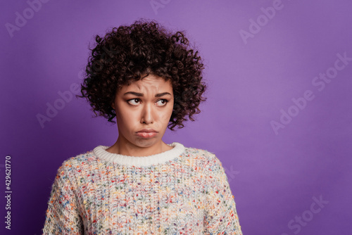 Beautiful unhappy girl grumpy look side empty space frowning isolated on violet background