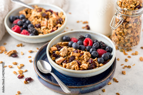 Homemade granola for to persons with nuts, seeds and berries in blue plate on table for healthy breakfast