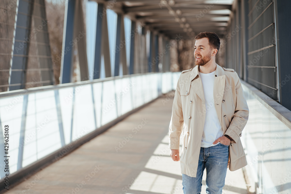Man walks down the street in beige coat Man walks down the street in beige coat
