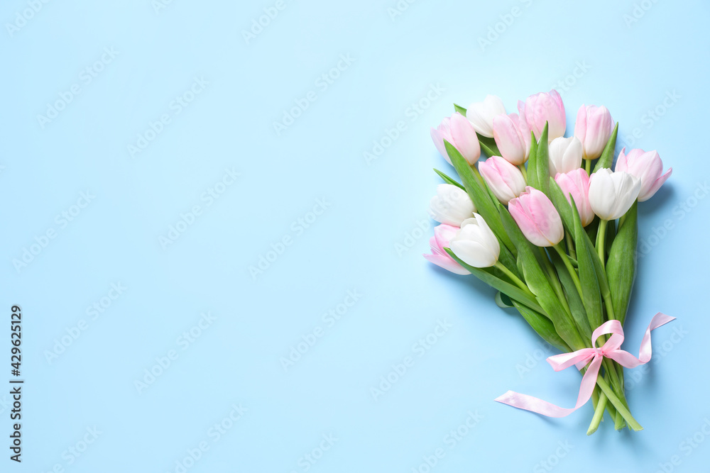 Beautiful pink spring tulips on light blue background, top view. Space for text - obrazy, fototapety, plakaty 