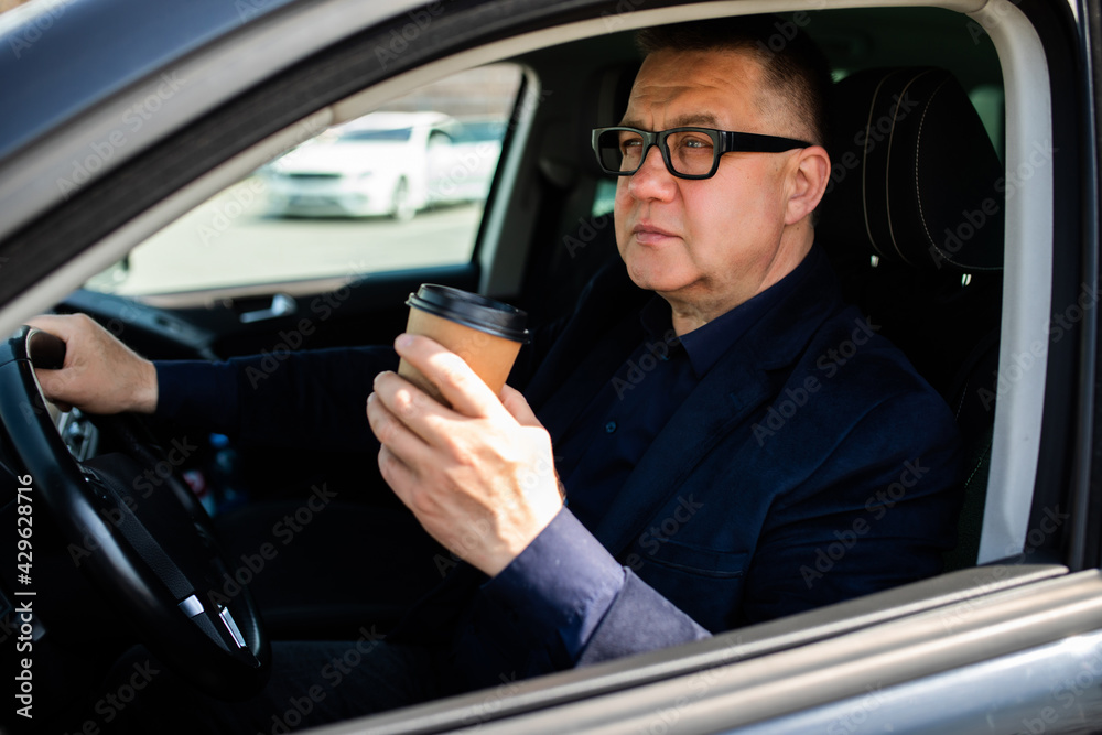 Elderly man experience self-driving smart car and has a cup of coffee