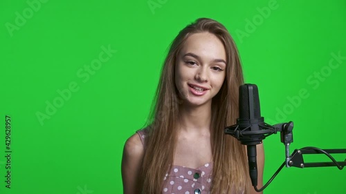 Smiling teen girl talking in microphone