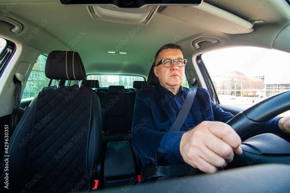 Handsome middle age man driving a car in the street Handsome middle age man driving a car in the street