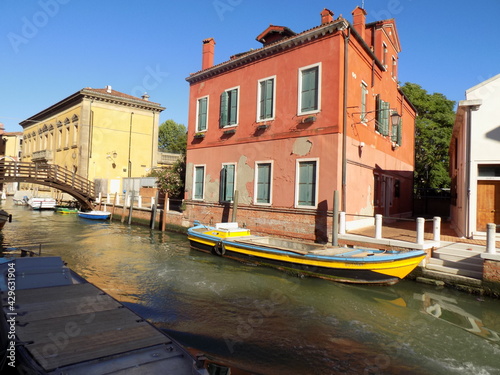 Yellow Long Boat in a Canal Venice, Italy, Docked Next to a House