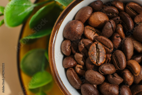 Arabica coffee beans in bright exotic yellow cup