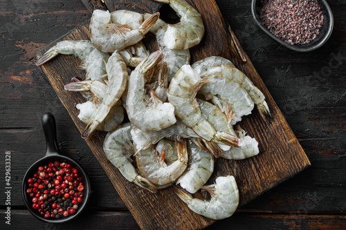 Tiger Prawns or Asian tiger Shrimps, on wooden cutting board, on old dark wooden table , top view flat lay